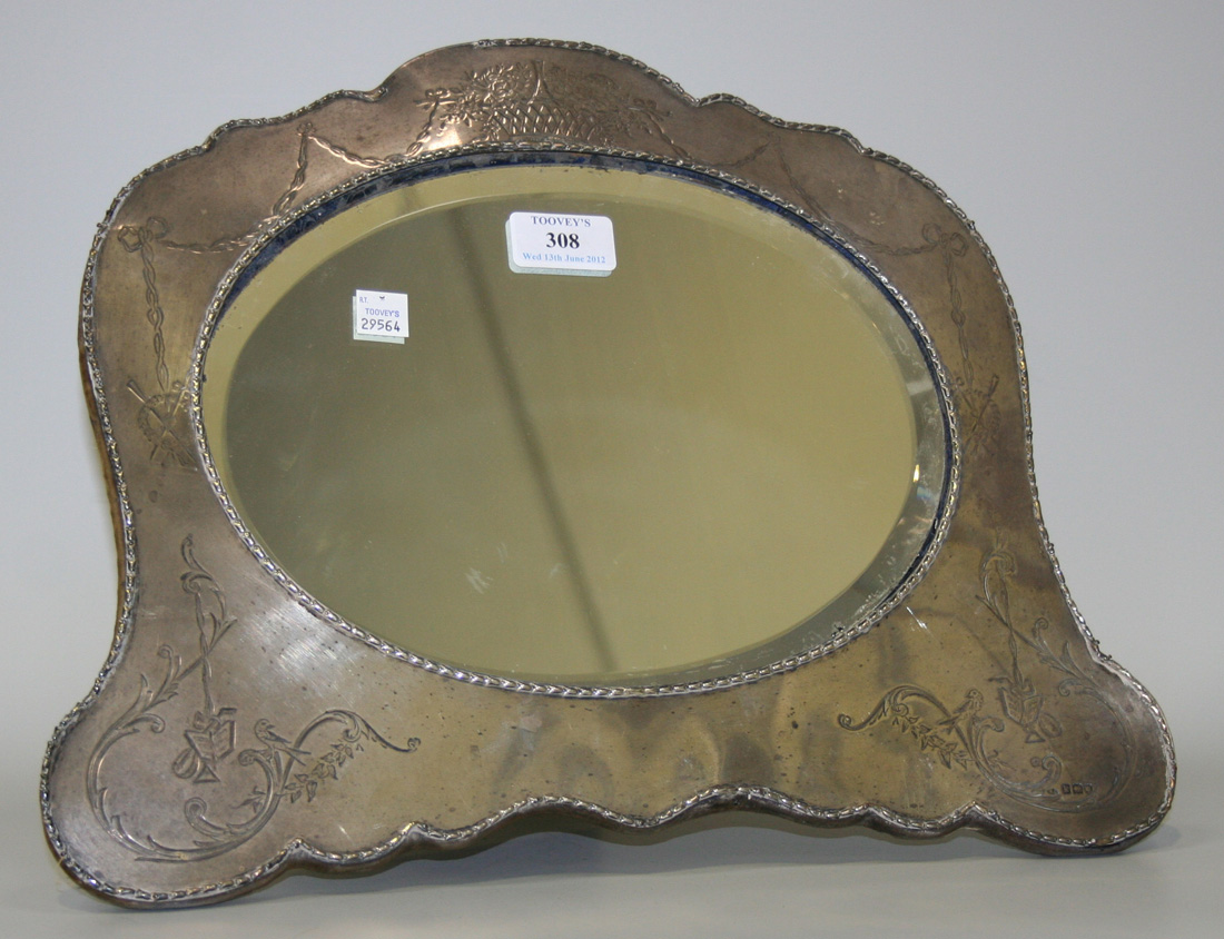 An Edwardian silver mounted dressing table mirror with oval aperture ...